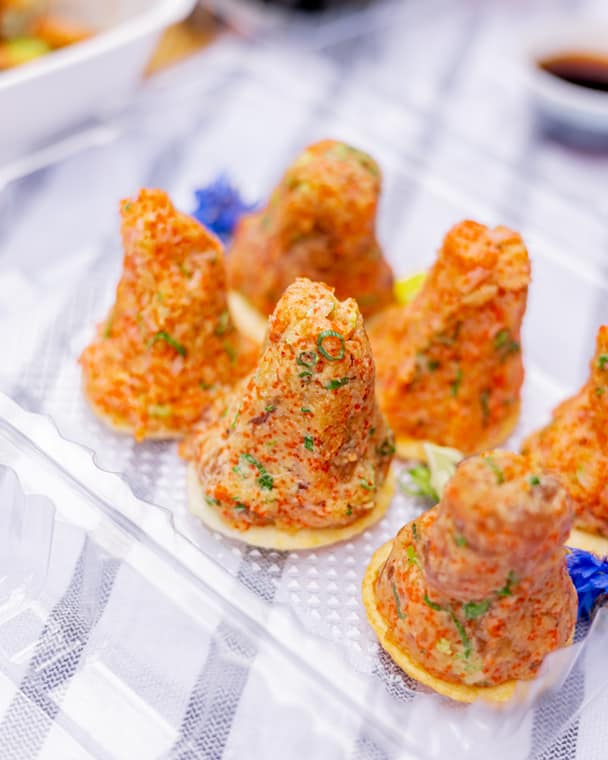 Cone-shaped sushi topped with spicy tartare and edible flowers