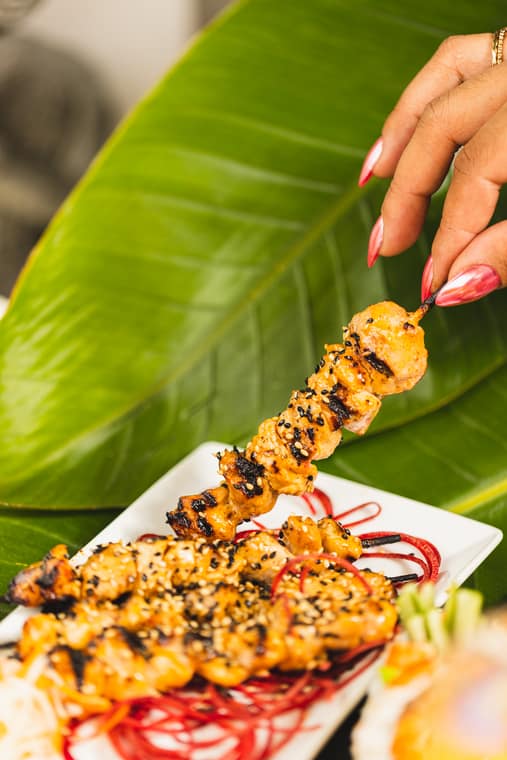 Grilled sesame skewer over a banana leaf