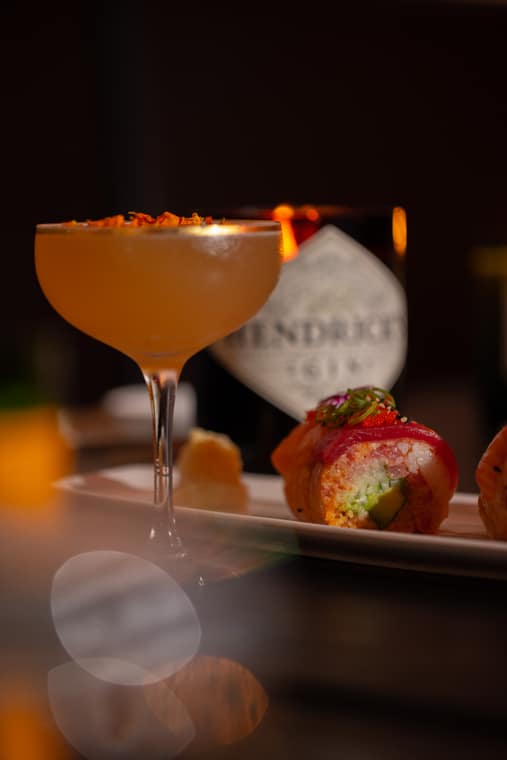 Cocktail served with a sushi roll at the bar
